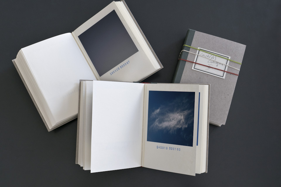 three books showing cloud photos