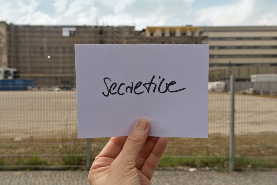 evaluation card "secretive" in front of abandoned buildings